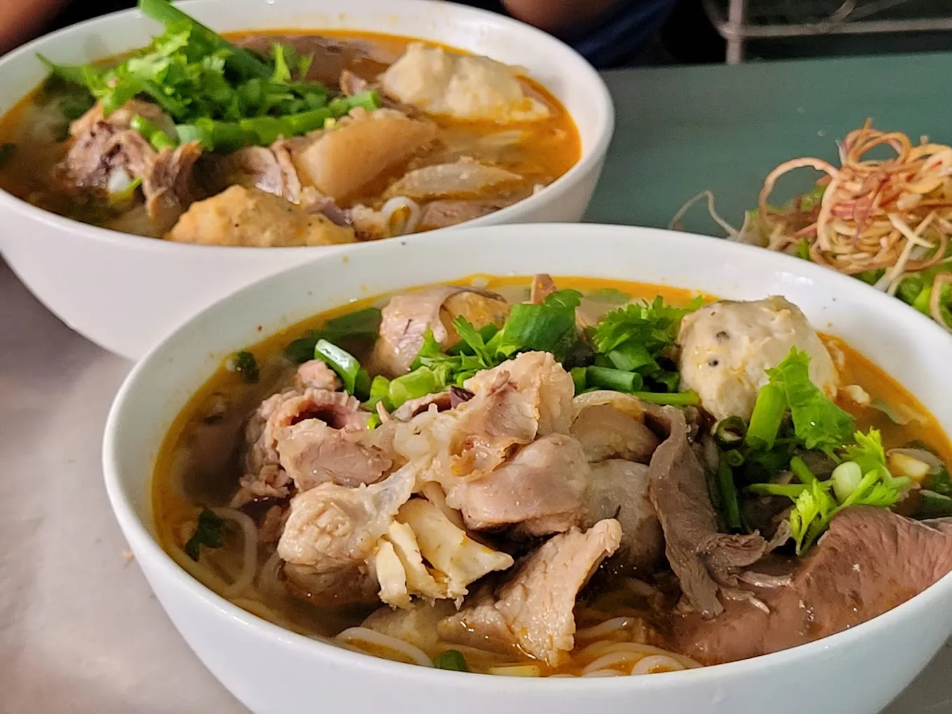 Alt: Bát bún bò Huế thơm ngon hấp dẫn với thịt bò, chả và rau sống tươi ngon.