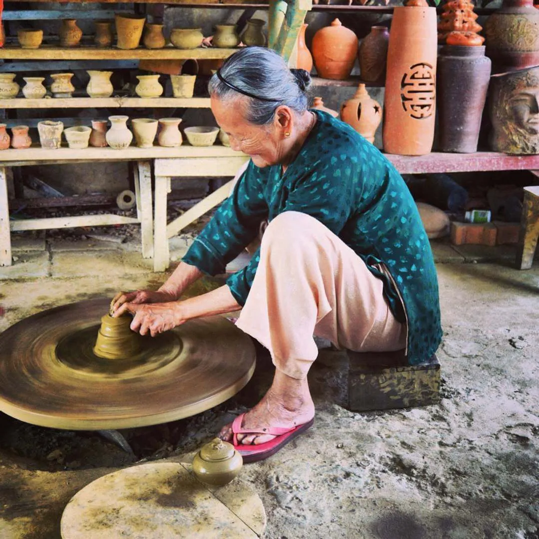 alt:  Du khách đang tham quan quy trình làm gốm tại làng gốm Thanh Hà