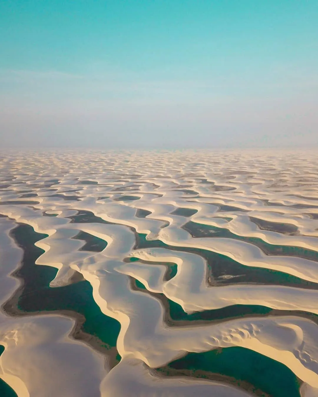 alt: Hồ nước trong xanh giữa những cồn cát trắng tại Lençóis Maranhenses