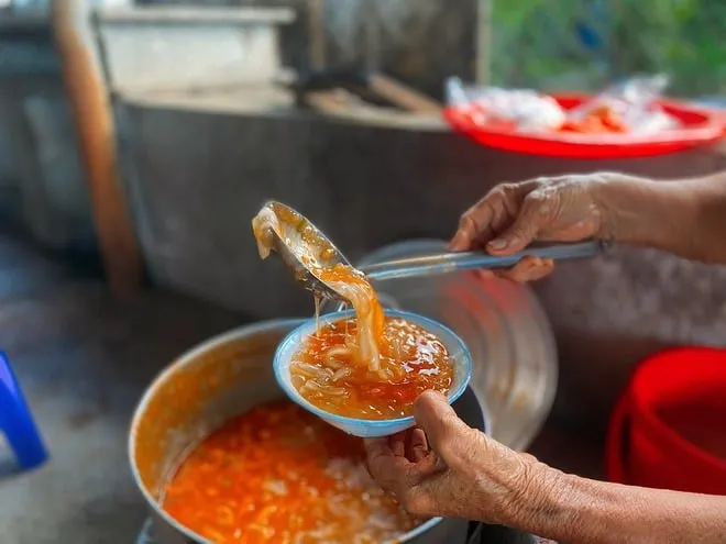 alt text: Bánh canh Nam Phổ với nước dùng đỏ au hấp dẫn, sợi bánh to và dẻo