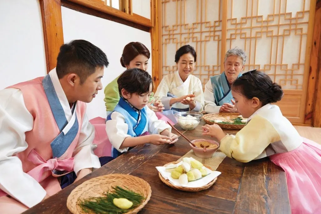 alt text: Cảnh gia đình Hàn Quốc mặc Hanbok chuẩn bị cho Tết Nguyên Đán