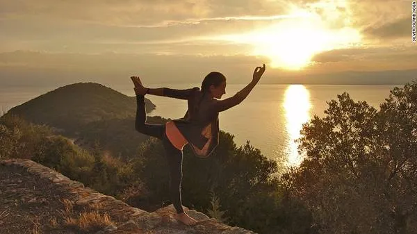 alt text: Cô gái đang tập yoga trên bãi biển