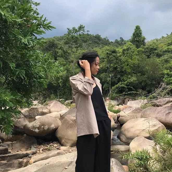 alt text: Con đường mòn dẫn vào Suối Ba Hồ, hai bên là cây cối um tùm, tạo nên một không gian xanh mát