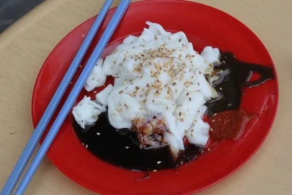 alt text: Đĩa Chee Cheong Fun với bánh bột trắng, nước sốt đen và mè