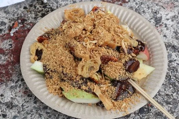 alt text: Đĩa gỏi Rojak với rau củ quả, hải sản, đậu phộng và nước sốt mắm tôm