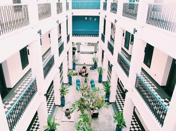 Alt text: Góc sân nhỏ với bàn ghế gỗ kiểu cũ tại Maison Vy