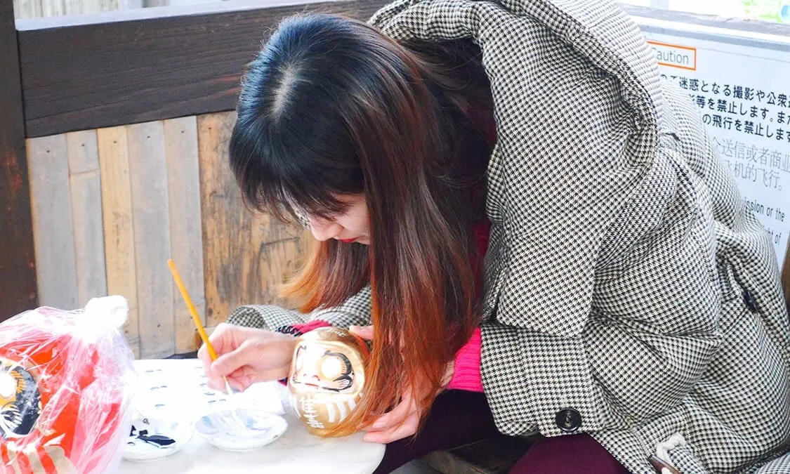 alt text: Hàng ngàn búp bê Daruma được đặt trong chùa Katsuoji