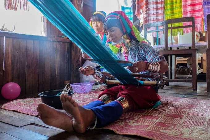 alt text: Một phụ nữ Kayan lớn tuổi với nhiều vòng đồng trên cổ