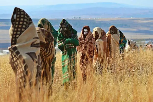 alt text: Nam thanh niên Xhosa với khuôn mặt bôi đất sét trắng trong nghi lễ trưởng thành. Họ phải sống tách biệt với bộ tộc trong một khoảng thời gian để rèn luyện sự tự lập.