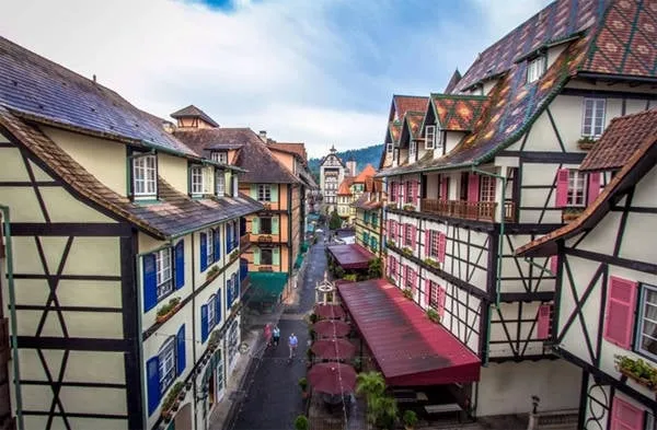 alt text: Ngôi làng kiểu Pháp tại Bukit Tinggi, Pahang, Malaysia với kiến trúc cổ kính, đường phố lát đá và những ngôi nhà đầy màu sắc