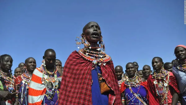 alt text: Người Maasai đang chào hỏi nhau bằng cách nhổ nước bọt. Đây là một cử chỉ thể hiện sự tôn trọng và chúc phúc trong văn hóa Maasai.