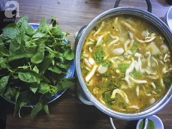 alt text:  Nồi lẩu gà lá é 668 với nước dùng trong, gà chặt miếng, lá é xanh tươi nổi bật trên mặt nước.