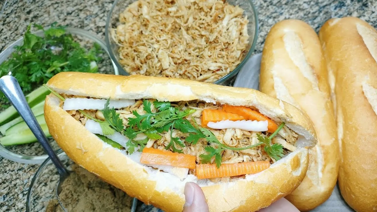 alt text: Ổ bánh mì gà xé nóng giòn, thơm phức, đầy ắp nhân thịt gà