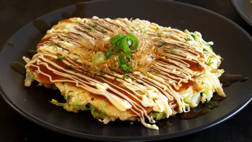alt text: Okonomiyaki, bánh xèo Nhật Bản với nhiều topping hấp dẫn