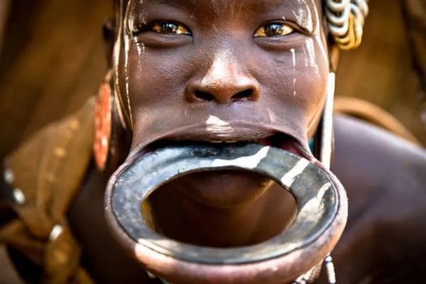 alt text: Phụ nữ Mursi với chiếc đĩa lớn ở môi dưới. Đây là một biểu tượng của vẻ đẹp và địa vị trong bộ tộc.