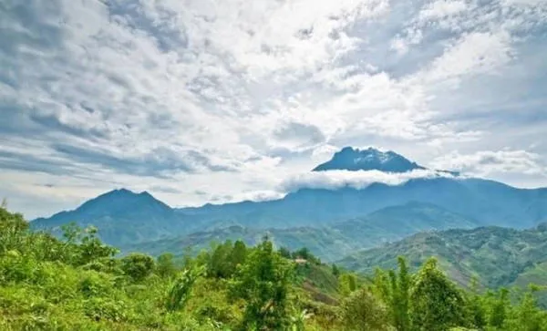 alt text: Thị trấn Kundasang, Sabah, Malaysia với những ngôi nhà nhỏ xinh nằm giữa thung lũng xanh tươi, bao quanh là những dãy núi trùng điệp