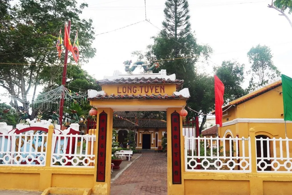 alt text: Toàn cảnh làng cổ Long Tuyền với những ngôi nhà cổ kính nằm san sát nhau, bao quanh bởi cây xanh tươi tốt