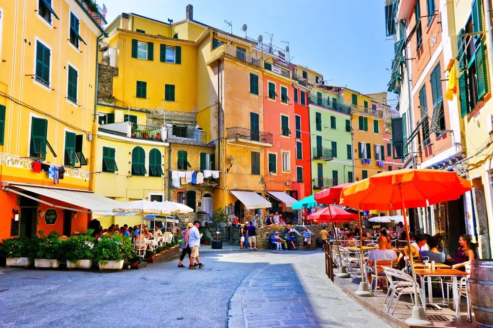 alt: Toàn cảnh làng Manarola nhìn từ xa, nổi bật với những ngôi nhà màu sắc trên vách đá