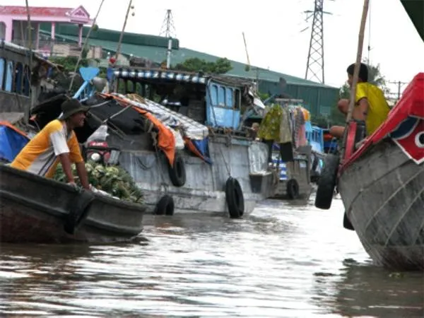 Anh Thành (trái) trò chuyện cùng bạn thuyền, thể hiện cuộc sống thường nhật trên sông nước.