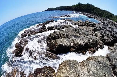 Bãi đá trầm tích quanh miệng núi lửa cổ bị tách thành nhiều cụm nên nước biển xô bờ tung trắng xóa chảy thành vệt dài theo kẽ đá như những dòng suối. Ảnh: Trí Tín