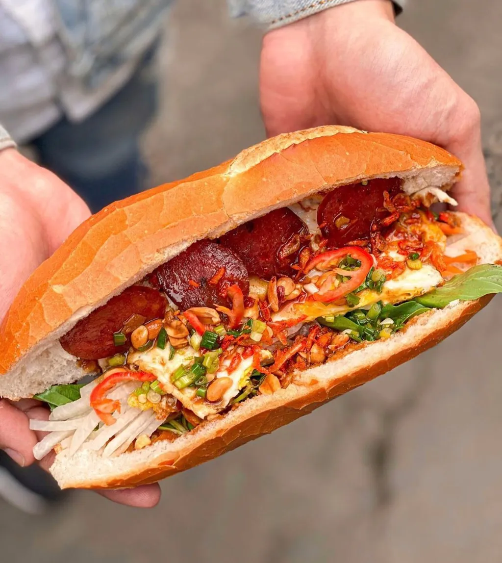 Bánh mì bò bía với màu sắc hấp dẫn, kết hợp giữa bò bía, lạp xưởng, đậu phộng, rau và ớt.