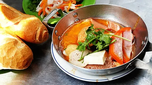 Bánh mì chảo thơm ngon, nóng hổi với trứng ốp la, pate, xíu mại tại một quán ăn sáng ở Quận 1, TP.HCM