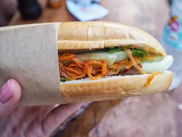 Bánh mì kẹp thịt Hà Nội - sự kết hợp hoàn hảo giữa ẩm thực Pháp và Đông Nam Á. Bánh mì giòn tan, nhân thịt pate thơm ngon cùng rau tươi.