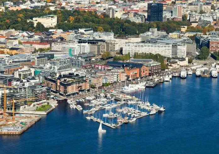 Cảnh vịnh hẹp Oslo với thuyền buồm và rừng cây xanh tươi.