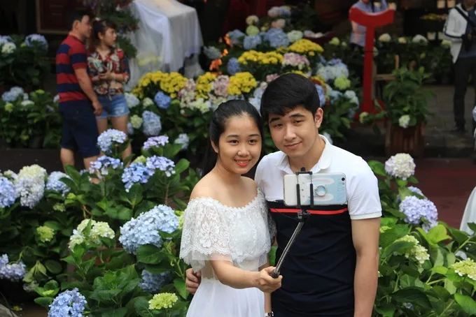 Cặp đôi chụp ảnh selfie tại vườn hoa