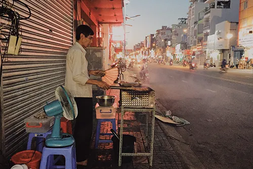 Chồng bà Ròm đang nướng sườn trên bếp than hồng. Ảnh: Tâm Linh.