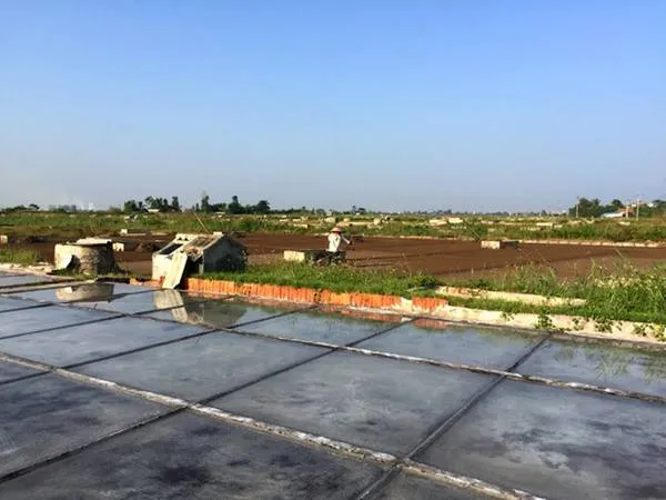 Công đoạn phơi nước biển trên sân xi măng để kết tinh muối. Ảnh: Băng Giang.