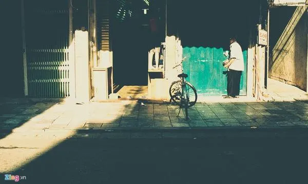 Cụ ông đạp xe đi mua báo sớm ở phố Hàng Ngang. 