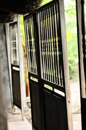 Cửa gỗ lim cổ kính, chắc chắn của ngôi nhà Bá Kiến vẫn trường tồn qua hơn một thế kỷ.