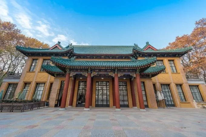 Cung điện Meiling (Mỹ Linh) nhìn từ trên cao, với hàng cây xanh bao quanh tạo thành hình dáng một sợi dây chuyền. Mái ngói xanh của cung điện nổi bật giữa màu xanh của cây cối.