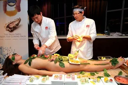 Đầu bếp đang bày trí sushi trên cơ thể người mẫu cho bữa tiệc Nyotaimori. Ảnh: Blogspot