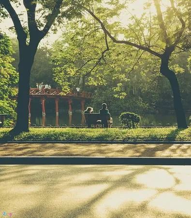 Đầu hè là khoảng thời gian được ví như mùa thu đầu tiên của Hà Nội, vì nắng dịu nhẹ và mát mẻ. Hai du khách nước ngoài đang tận hưởng cái nắng đầu mùa. 