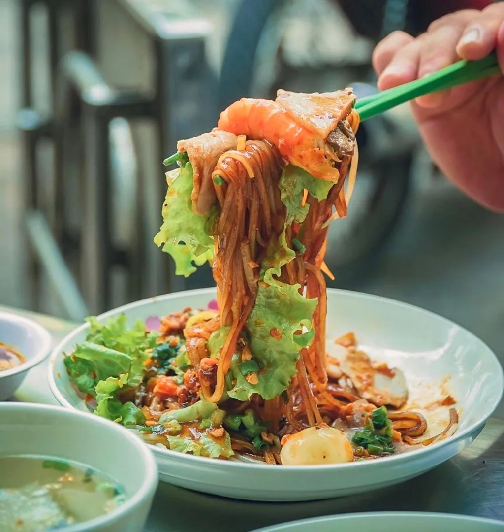 Đĩa hủ tiếu Sa Đéc với đầy đủ topping như thịt nạc, tôm, trứng cút, bò viên và rau xà lách.