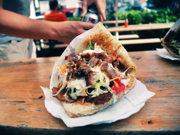 Doner Kebab - món ăn đường phố phổ biến với bánh mì pita kẹp thịt nướng, rau và sốt.