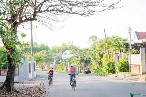 Du khách đạp xe trên con đường thoáng mát ở xã Hiếu Liêm, gần Hồ Trị An. Đạp xe là một hoạt động thú vị để khám phá vẻ đẹp của Hồ Trị An và cuộc sống của người dân địa phương.
