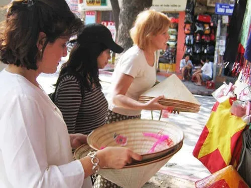 Du khách nước ngoài mua quà lưu niệm tại Hà Nội