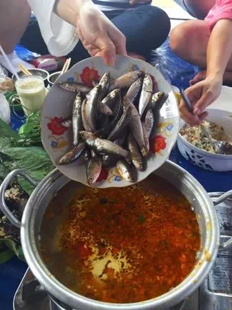 Du khách thưởng thức lẩu cá linh bông điên điển, đặc sản miền Tây mùa nước nổi.