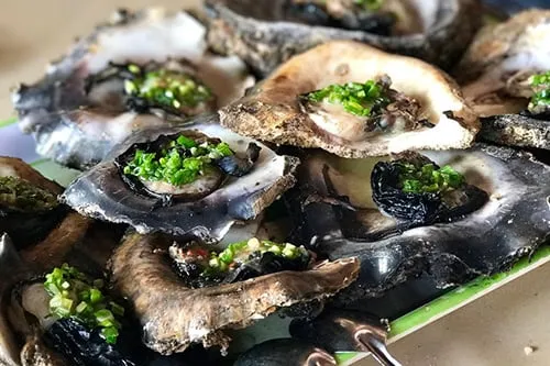 Hàu nướng mỡ hành trên bếp than hồng, thơm phức, hấp dẫn thực khách. Ảnh: Dano