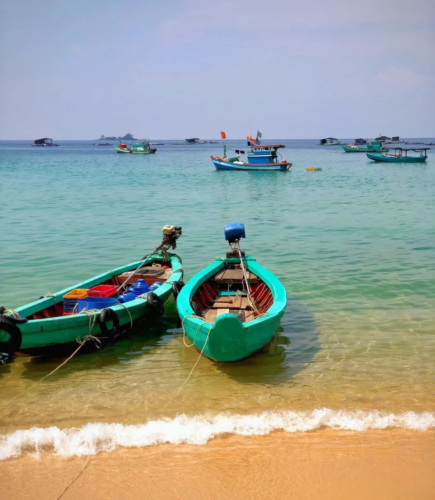 Làng chài Gành Dầu. Alt: Cảnh làng chài Gành Dầu yên bình với những chiếc thuyền neo đậu trên bờ biển.