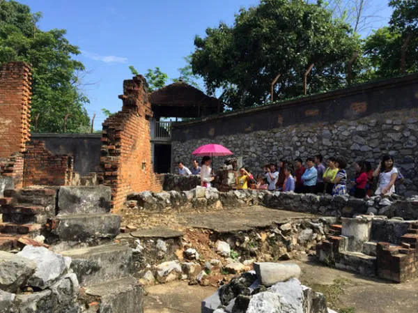 Một đoàn khách đang chăm chú nghe giới thiệu của hướng dẫn viên ở di tích Nhà tù Sơn La
