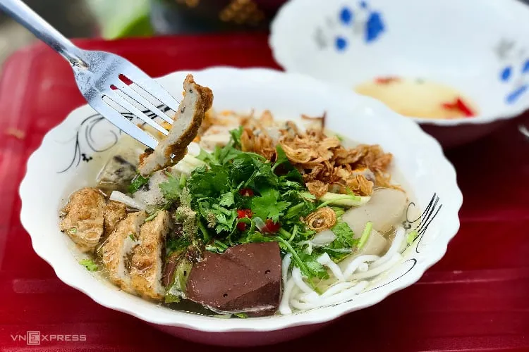 Một tô bánh canh chả cá Phan Thiết đầy đủ với chả cá chiên, chả cá hấp và nước dùng trong veo.