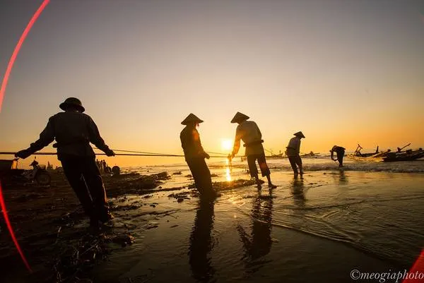 Ngư dân Hải Lý cần mẫn kéo lưới trên bãi biển trong ánh nắng sớm.