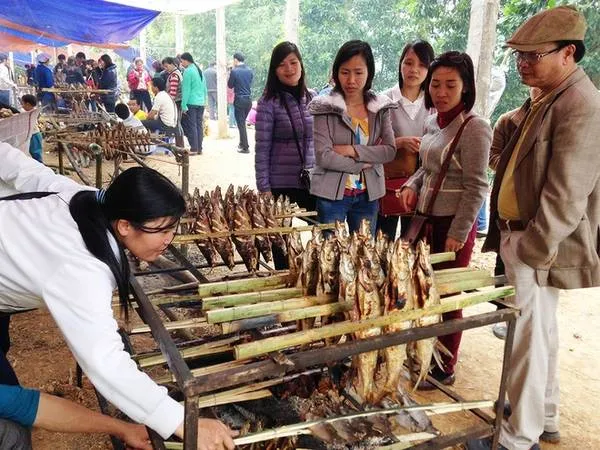 Người dân địa phương nướng cá trên bếp than, phục vụ du khách tại Thung Nai.