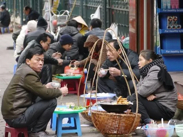 Người dân ngồi ăn trên vỉa hè Hà Nội