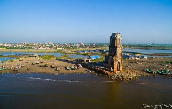 Nhà thờ đổ Hải Lý nằm sát biển, nổi bật giữa những con thuyền đánh cá nhiều màu sắc.