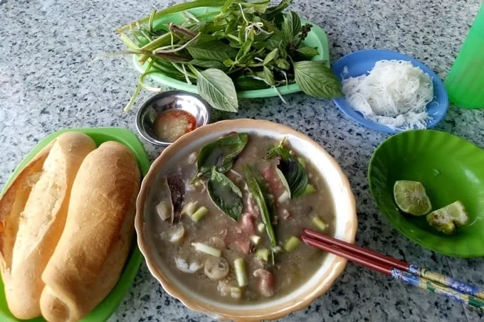 Nồi cháo bò bún tươi đang được nấu trên bếp lửa